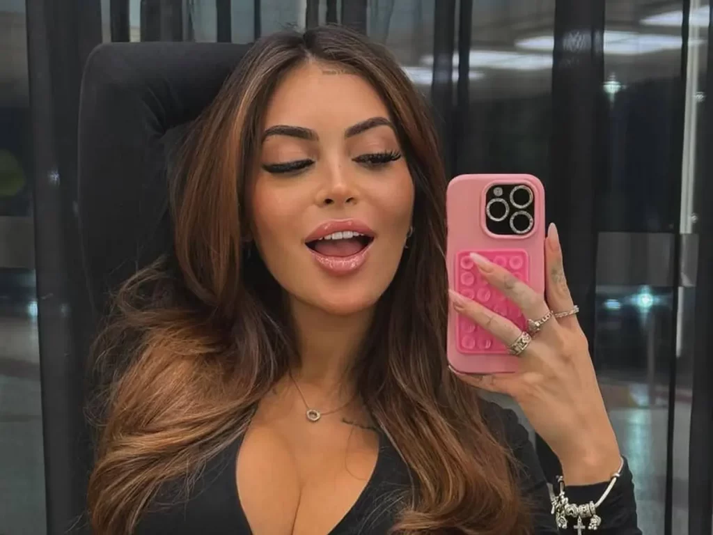 Mari Ávila segura o celular enquanto interage com fãs sobre o fetiche corno submisso