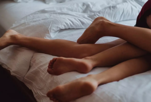 Casal na cama representando o fetiche cuckold masculino.