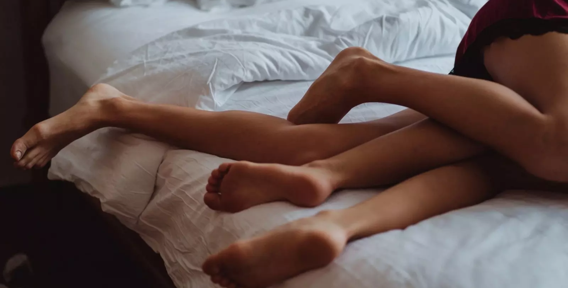 Casal na cama representando o fetiche cuckold masculino.