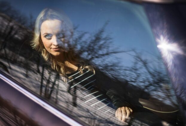 Casal no carro observado à distância, representando o fetiche do dogging e voyeurismo com discrição e excitação