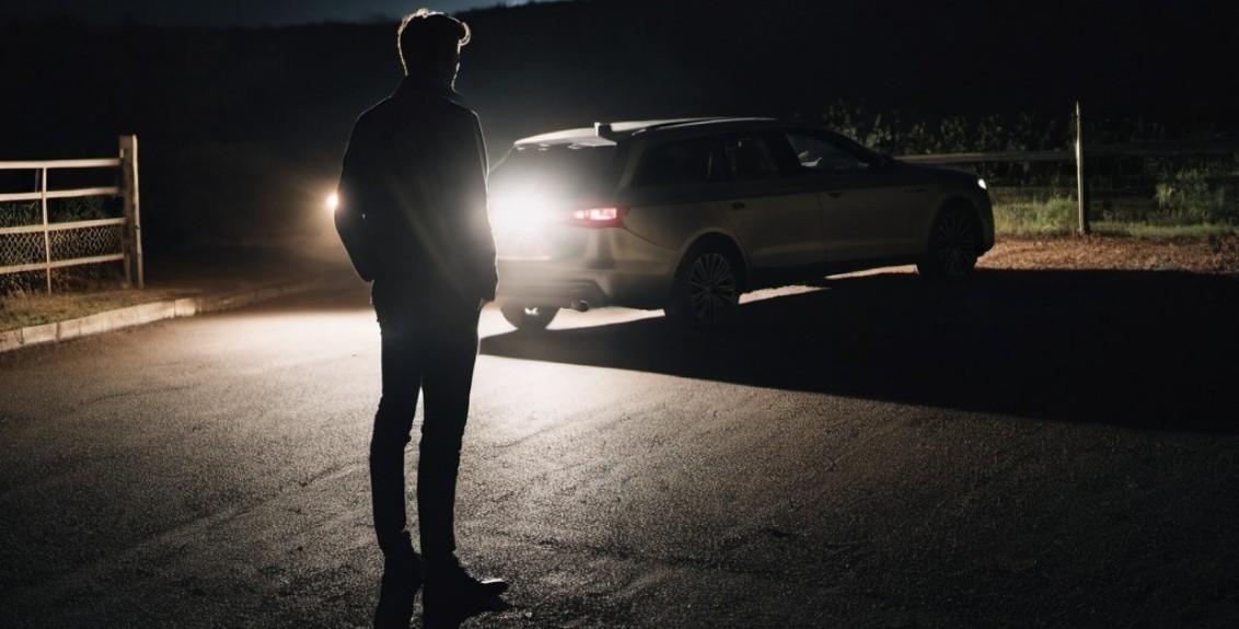 Homem observando casal passando de carro por local de dogging, representando os relatos de dogging.